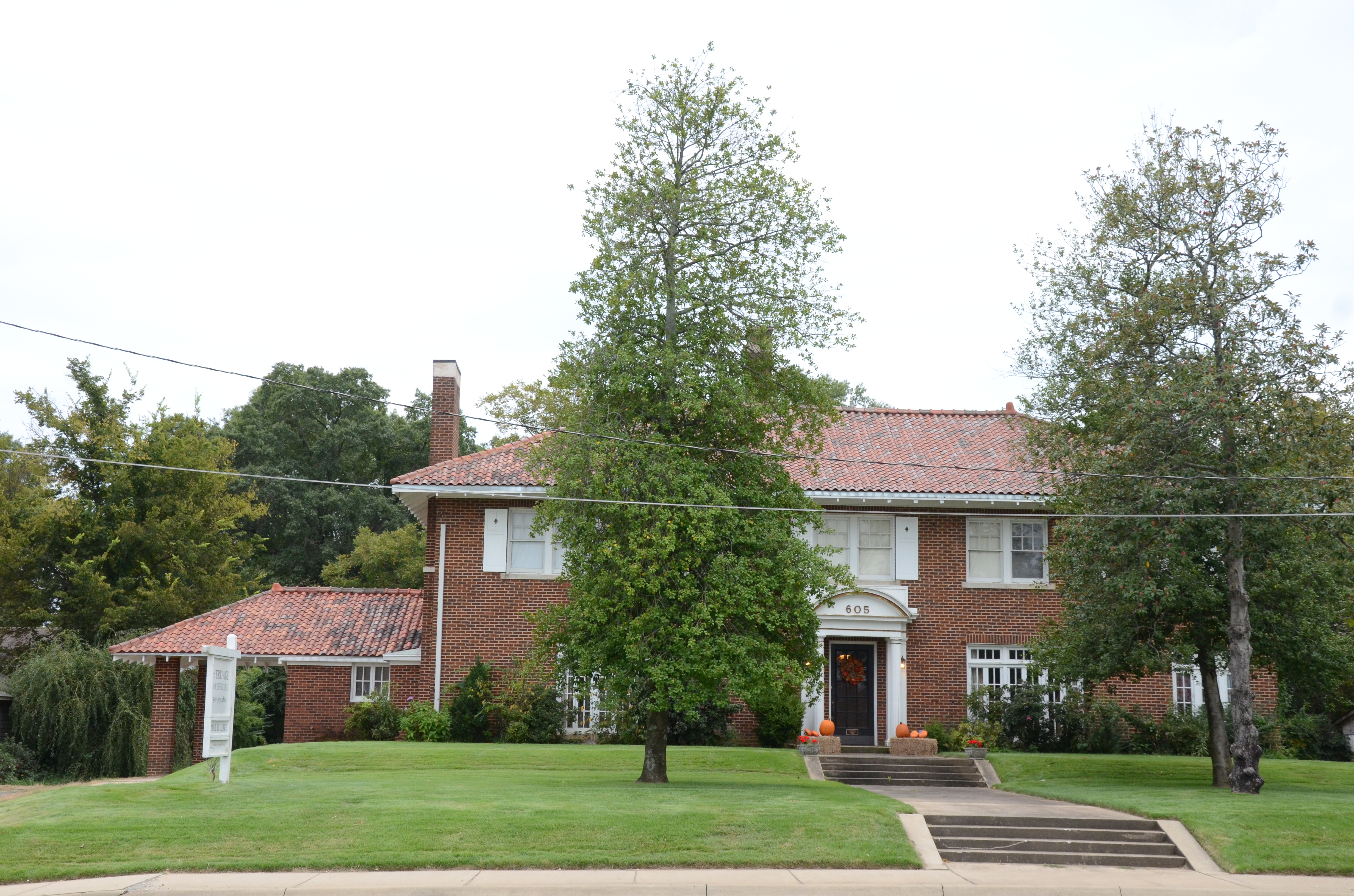 Front of Lightle House, a two-story brick Colonial Revival with a clay-tile hip roof, porte-cochère, and the house number 605 over the door, on East Race Avenue in Searcy, Arkansas.