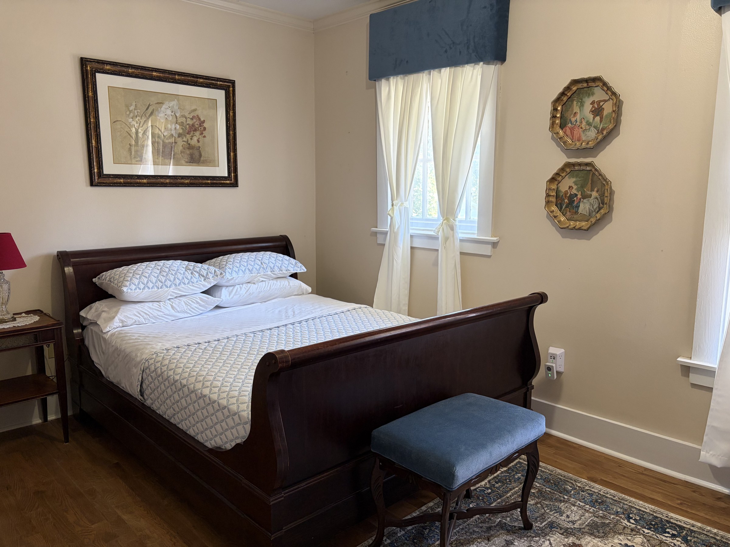 The Lightle Room sleigh bed with a blue velvet bench at the foot and a floral print above the headboard.