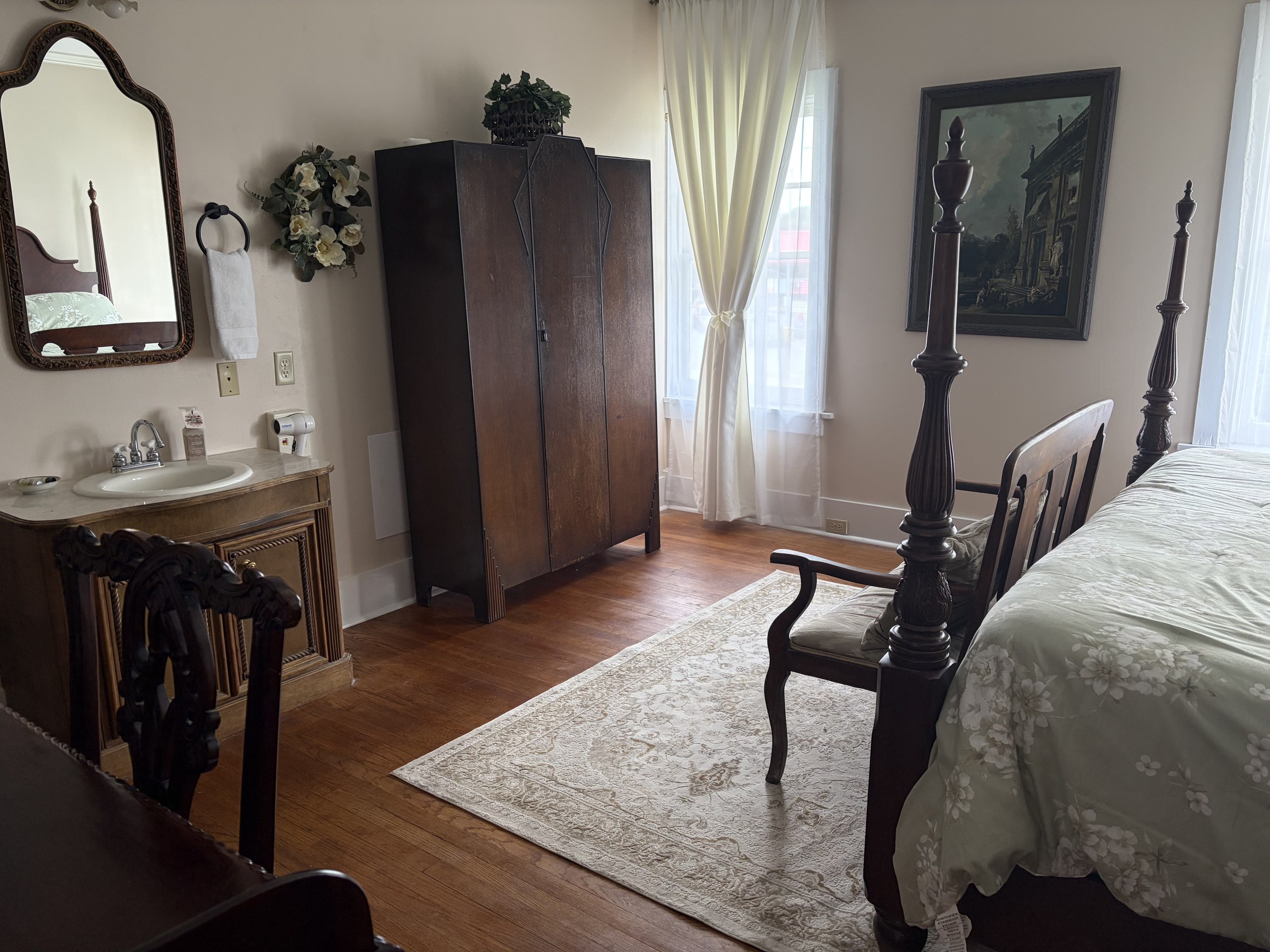 Lillian: vanity with marble sink, armoire, and king bed.