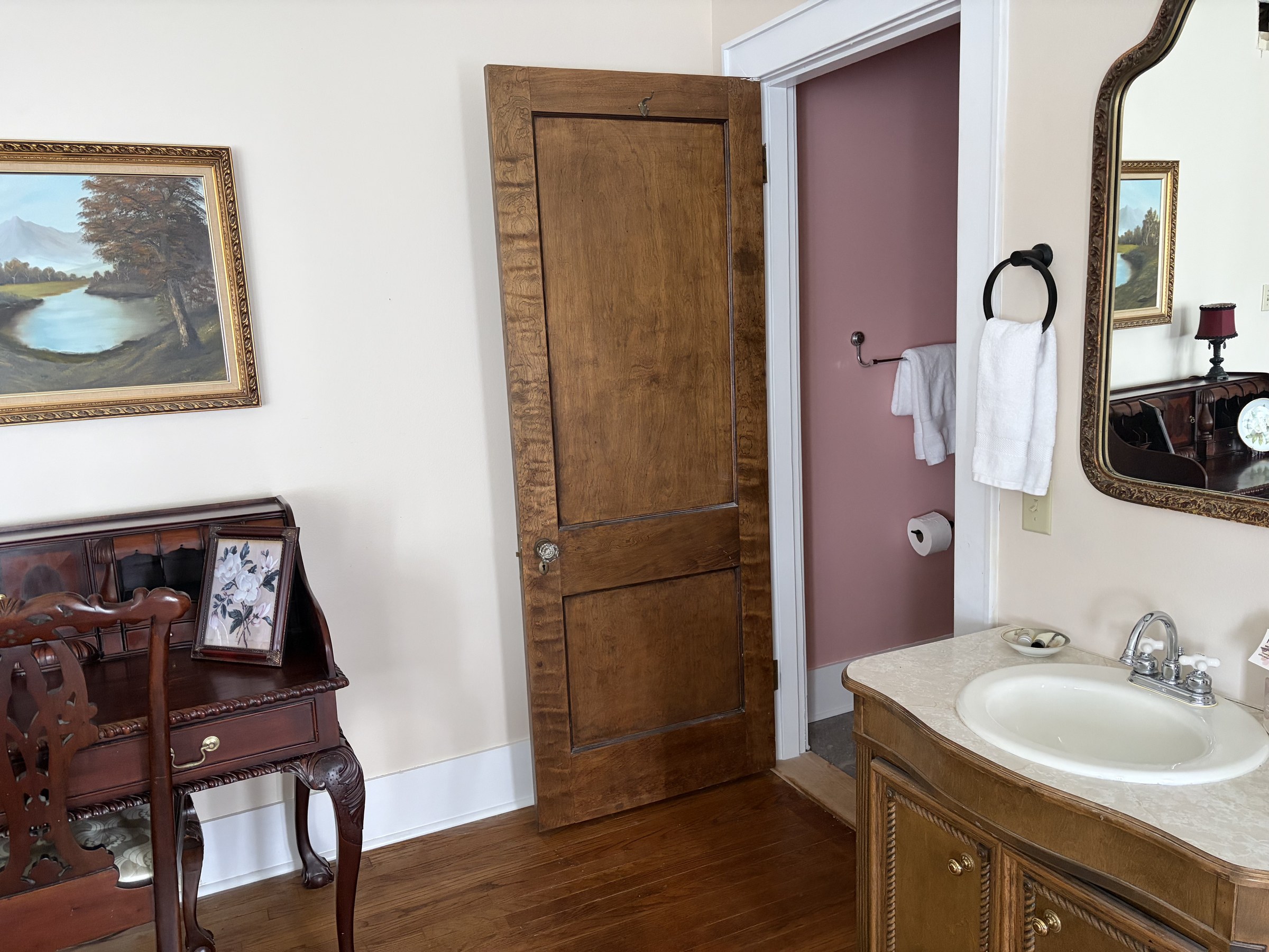 Lillian: roll-top desk and bathroom vanity with gold-framed mirror.
